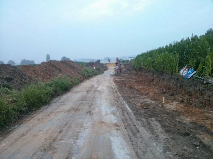 Der Bahnübergang Bödinghausen zum Beginn des Ausbaus im Juli 2014. Am Wegesrand ist noch die alte Geschwindigkeitsbegrenzung auf 10km/h zu sehen