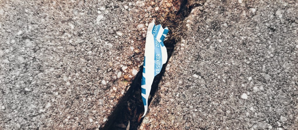 Stückchen Plastik zwischen Pflastersteinen